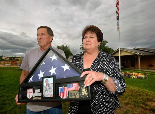 Al Hartmann  |  The Salt Lake Tribune 
Betty and Rodney Workman of Blanding hold a case of dog tags, Marine patches and the American flag that honored their son Jason who was buried with honors at Arlington Cemetery.  Jason Workman, a member of Seal Team 6 was among 38 military personnel shot down by Taliban fighters in a Chinook helicopter on Aug. 6, 2011. It was the largest loss of U.S. life in the Afghanistan campaign.  Two Utahns were on the helicopter,  Taylorsville's Jared Day and Blanding's Jason Workman. Five years later, family and friends still grapple with their absence while battling to keep alive their memory ó Workman, as a big, daring family man with a kind heart and Day as a "goofball" who loved video games and anime and who could make people laugh during times of extreme stress.
The two men shared a birthday, Aug. 12.