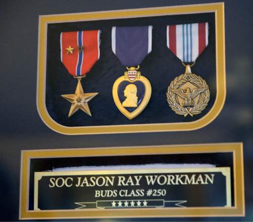 Al Hartmann  |  The Salt Lake Tribune 
Jason Workman's double Bronze Star, Purple Heart and Presidential medal at his parents' Betty and Rodney Workman home in Blanding.  Jason Workman, a member of Seal Team 6 was among 38 military personnel shot down by Taliban fighters in a Chinook helicopter on Aug. 6, 2011. It was the largest loss of U.S. life in the Afghanistan campaign.  Two Utahns were on the helicopter,  Taylorsville's Jared Day and Blanding's Jason Workman. Five years later, family and friends still grapple with their absence while battling to keep alive their memory -- Workman, as a big, daring family man with a kind heart and Day as a "goofball" who loved video games and anime and who could make people laugh during times of extreme stress.
The two men shared a birthday, Aug. 12.