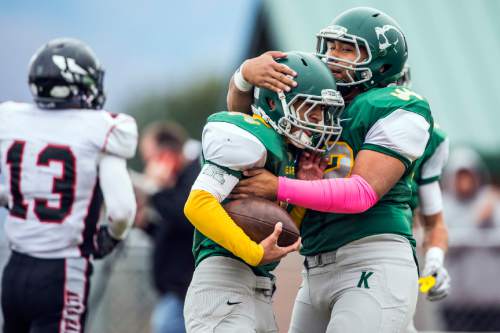 Chris Detrick  |  The Salt Lake Tribune
Kearns' Sese Felilia (27) is hugged by Kearns' Fosi Nathan (62) after scoring a touchdown during the game at Kearns High School Friday October 30, 2015.