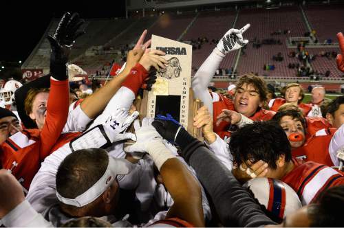 Scott Sommerdorf   |  The Salt Lake Tribune
East players celebrate with the 4A trophy after East beat Timpview 49-14 for the Utah 4A championship, Friday, November 20, 2015.