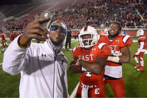Scott Sommerdorf   |  The Salt Lake Tribune
East QB Johnnie Lang takes a photo with a coach as]fter East beat Timpview 49-14 for the Utah 4A championship, Friday, November 20, 2015.