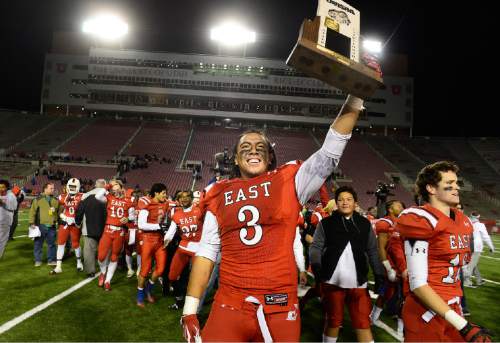 Scott Sommerdorf   |  The Salt Lake Tribune
East's Soni Fonua shows the 4A trophy to fans after East beat Timpview 49-14 for the Utah 4A championship, Friday, November 20, 2015.