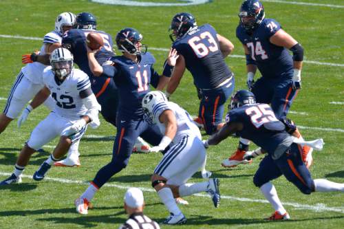 Chris Detrick  |  The Salt Lake Tribune
Virginia Cavaliers quarterback Greyson Lambert (11) passes the ball under pressure from Brigham Young Cougars defensive back Dallin Leavitt (2) during the game at LaVell Edwards Stadium Saturday September 20, 2014.  Virginia is winning the game 16-13 at halftime.
