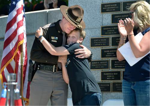 Scott Sommerdorf   |  The Salt Lake Tribune  
After speaking at the Utah Law Enforcement Memorial following the "Ride for the Fallen", Jack Barney the son of fallen officer Doug Barney, hugs UHP Colonel Michael Rapich, Sunday, August 21, 2016.