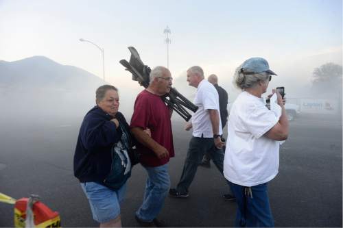 Scott Sommerdorf   |  The Salt Lake Tribune  
After the fall of the smokestacks, people who had gathered for the show scurried out of the area to avoid the dust cloud that soon engulfed the area, Sunday, August 21, 2016.