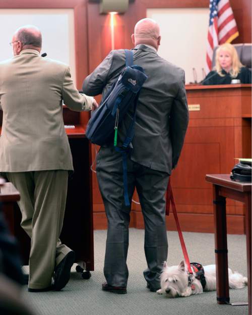 Al Hartmann  |  The Salt Lake Tribune
Timothy Lawson, center, dubbed a "fixer" for former Utah Attorney General Mark Shurtleff appears in Judge Katie Bernards-Goodman's courtroom in Salt Lake City Monday April 25. His defense lawyer Ron Yengich, left, and his service dog Prince at his side. 
Lawson is charged with six felonies -- including counts of tax evasion, witness tampering, obstruction of justice and a pattern of unlawful conduct -- stemming from allegations that he attempted to intimidate or threaten individuals with ties to Shurtleff and his successor, John Swallow.