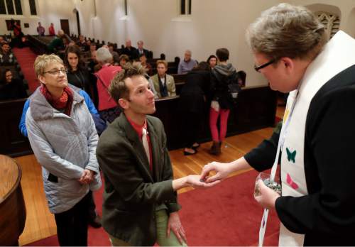 Francisco Kjolseth | The Salt Lake Tribune
Alexis Baigue, center, attends a Christmas interfaith service held at St. Paulís Episcopal Church in Salt Lake where people set down a pebble representing a burden to "receive something beautiful instead" following the service to affirm the dignity and worth of all people. The service, titled ìSeeing Christ In Every Child,î was prompted by ongoing spiritual isolation and pain expressed by LGBTQ people of faith.