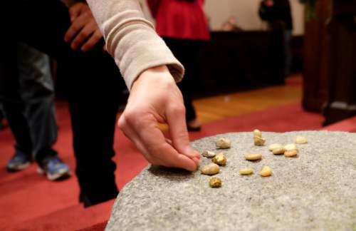 Francisco Kjolseth | The Salt Lake Tribune
People attending a Christmas interfaith service held at St. Paul's Episcopal Church in Salt Lake lay down a pebble representing a burden upon a millstone to "receive something beautiful instead" following the service to affirm the dignity and worth of all people. The service, titled "Seeing Christ In Every Child," was prompted by ongoing spiritual isolation and pain expressed by LGBTQ people of faith.