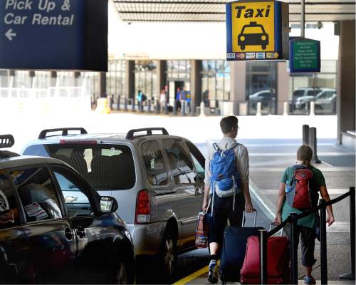 Scott Sommerdorf   |  The Salt Lake Tribune  
Travelers walk past the taxi stand at the Salt Lake City International Airport, Wednesday, July 20, 2016.  There have been complaints from airport visitors about largely unregulated taxi fares. Cabs no longer need to have meters, can largely charge any fare they want (except in SLC itself), and need not tell passengers in advance how much they will charge.