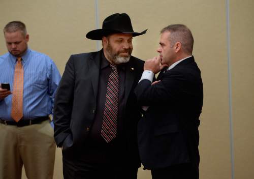 Scott Sommerdorf   |  The Salt Lake Tribune
Rick Koerber, center, confers with his attorney Marcus Mumford, right prior to speaking at a news conference the day after a federal judge tossed out 18 charges against Koerber that had alleged he operated a giant Ponzi scheme through his real estate company, Friday, August 15, 2014.