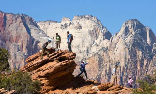 Al Hartmann  |  The Salt Lake Tribune
Hikers play on the sandstone rocks from the Canyon Overlook Trail with a view into Zion canyon.