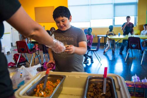 Chris Detrick  |  The Salt Lake Tribune
Katie Elmer serves Matthew Spence a hot meal, from the CAP Central Kitchen, at the YMCA Community Family Center in Taylorsville on Friday, Aug. 19, 2016.