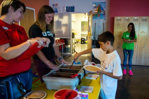 Chris Detrick  |  The Salt Lake Tribune
Brittany Breneman, left, and Katie Elmer watch as Vincent Bitton gets a meal, which was made CAP Central Kitchen and delivered to the YMCA Community Family Center in Taylorsville on Friday, Aug. 19, 2016.