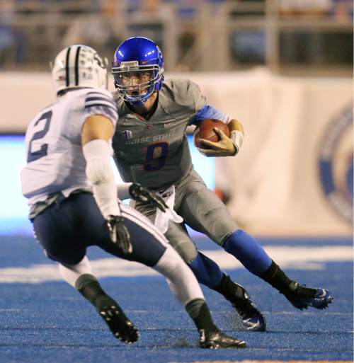 Boise State quarterback Grant Hedrick (9) looks to evade BYU defensive back Dallin Leavitt (2) during an NCAA college football game in Boise, Idaho, Friday, Oct. 24, 2014. (AP Photo/The Idaho Statesman, Kyle Green) MANDATORY CREDIT; LOCAL TELEVISION OUT (KTVB 7)