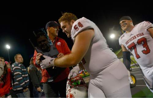 Leah Hogsten  |  The Salt Lake Tribune
Southern Utah Thunderbirds defensive lineman Keyan Norman (54) hands over the rivalry trophy between the two teams in celebration of their win to Southern Utah Thunderbirds head coach Ed Lamb.  Southern Utah University defeated Weber State University 44-0, October 2, 2015 at Stewart Stadium in Ogden.