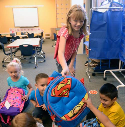 Al Hartmann  |  The Salt Lake Tribune
Alia Leonard hands out a backpack to each student in a kindergarten class at Bennion Elementary School on Wednesday. She raised enough money for more than 300 backpacks with school supplies for every student in the school.