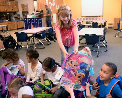 Al Hartmann  |  The Salt Lake Tribune
Alia Leonard hands out a backpack to each student in a kindergarten class at Bennion Elementary School on Wednesday, Aug. 31.  She raised enough money for more than 300 backpacks with school supplies for every student in the school.
