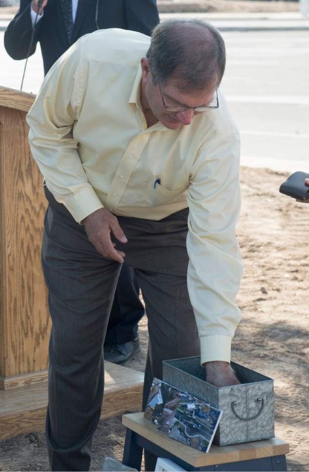 Rick Egan  |  The Salt Lake Tribune

Layton City Mayor Bob Stevenson places items in a time capsule, symbolizing partnerships behind the Hill Field road project. Wednesday, August 31, 2016.