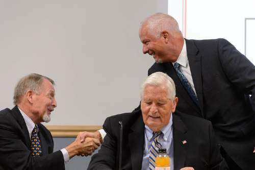 Trent Nelson  |  The Salt Lake Tribune
Jerry Benson, standing, right, shakes hands with Robert McKinley before Benson was sworn in as the new president/CEO of the Utah Transit Authority (UTA), Wednesday August 31, 2016. H. David Burton is seated at right.