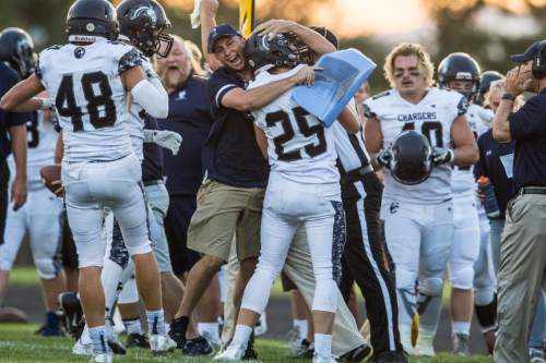Chris Detrick  |  The Salt Lake Tribune
Corner Canyon's Blake Emery (25) gets a hug from a member of the coaching staff after blocking a pass on 4th down during the game at Roy High School Friday September 2, 2016. Corner Canyon defeated Roy 36-6.