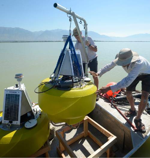 Al Hartmann  |  The Salt Lake Tribune
Environmental scientists Marshall Baillie, left, and Brent Shaw with Utah Division of Water Quality prepare one of three solar buoys housing probes called sondes going into Utah Lake Monday August 29.  The sondes or sensors should be able to monitor lake conditions to give a warning when nutrients are building up to the point that they'll have another massive algal bloom like the one in July.