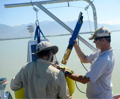 Al Hartmann  |  The Salt Lake Tribune
Environmental scientists Brent Shaw, left Marshall Baillie,with Utah Division of Water Quality prepare one of three solar buoys housing probes called sondes into Utah Lake Monday August 29.  The sondes or sensors should be able to monitor lake conditions to give a warning when nutrients are building up to the point that they'll have another massive algal bloom like the one in July.
