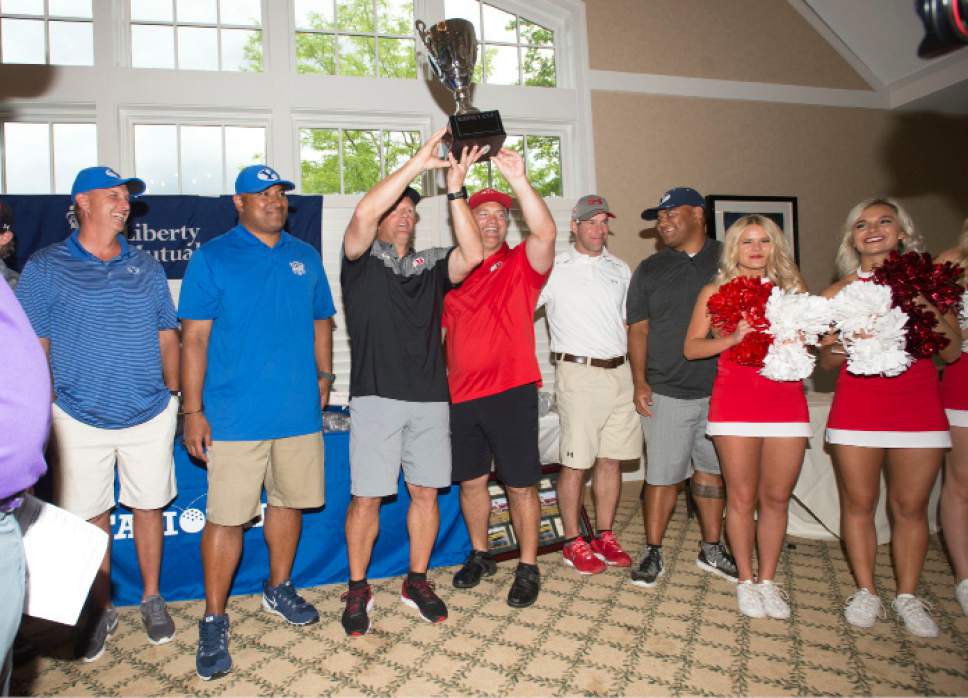 Steve Griffin / The Salt Lake Tribune

University of Utah head coach Kyle Whittingham and tight ends coach Fred Whittingham hold up the winning trophy as they stand with BYU head coach Kalani Sitake and offensive coordinator Ty Detmer following the rivalry for charity (National Kidney Foundation) golf tournament at Hidden Valley Country Club in Sandy, Utah Monday June 13, 2016. The tournament pitted the Utah football team coaches against the BYU football coaches with the losing team singing the others fight song. Sitake and his team held up their end of the bargain and sang the University of Utah fight song after falling to the Utah coaches in the tournament.
