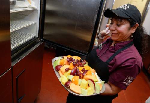 Francisco Kjolseth | The Salt Lake Tribune
Nuvia Vasquez, a 21-year employee of Chuck-A-Rama bulls out a trash of freshly cut fruit as the restaurant celebrates its 50th anniversary on Wednesday, at the original location near 700 East and 400 South in Salt Lake City.