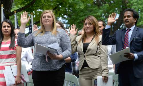 Al Hartmann  |  Tribune file photo
Sixteen people raise their hands to be sworn in as new U.S. citizens in a naturalization ceremony Friday July 1 at the Freedom Festival in Scera Park in Orem.  They are from Austrailia, Brazil, Canada, Ecuador, El Salvador, Honduras, Mexico, South Africa, India and the United Kingdom.
