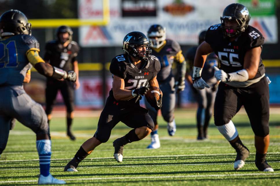 Chris Detrick  |  The Salt Lake Tribune
Alta's Joshua Davis (20) runs past Taylorsville's Pastor james Lewis (21) during the game at Alta High School Friday August 19, 2016.