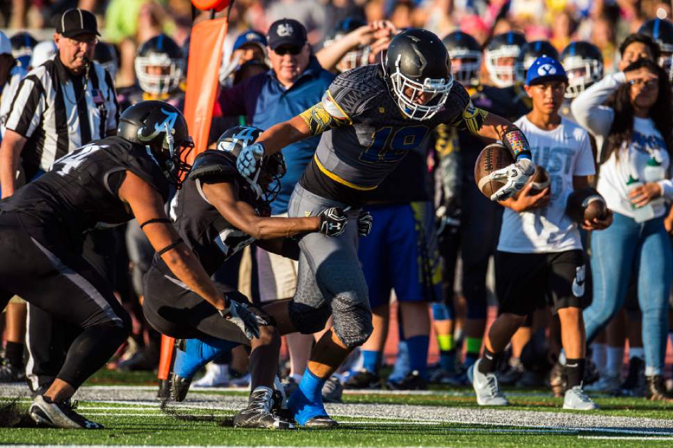 Chris Detrick  |  The Salt Lake Tribune
Taylorsville's Chase Hess (18) runs past Alta's Zach Alsop (24) and Alta's MJ Tafisi (44) during the game at Alta High School Friday August 19, 2016.