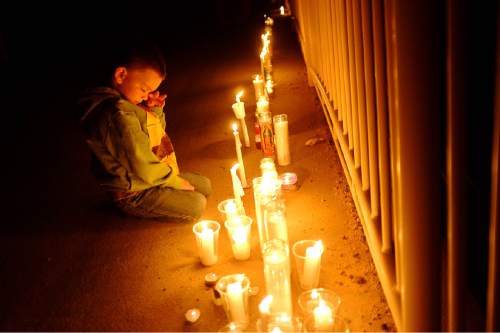 Trent Nelson  |  The Salt Lake Tribune
Drexton Musser, 4, looks down at candles on a bridge over Short Creek as residents of Hildale, UT and Colorado City, AZ, hold a memorial to the victims of the 2015 flash flood, Wednesday September 14, 2016. Musser's parents say he asks about missing Tyson Black on a daily basis. His dad Terrill, was a big part of the search effort and helped organize tonight's event.
