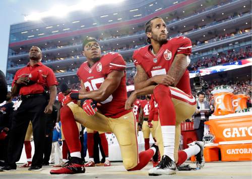 FILE - Int his Monday, Sept. 12, 2016, file photo, San Francisco 49ers safety Eric Reid (35) and quarterback Colin Kaepernick (7) kneel during the national anthem before an NFL football game against the Los Angeles Rams in Santa Clara, Calif. The dozen NFL players who have joined Kaepernick's protest of social injustices by kneeling or raising a fist during the national anthem have faced vitriolic, sometimes racist reactions on social media and at least one has lost endorsements. None are deterred by the backlash. (AP Photo/Marcio Jose Sanchez, File)