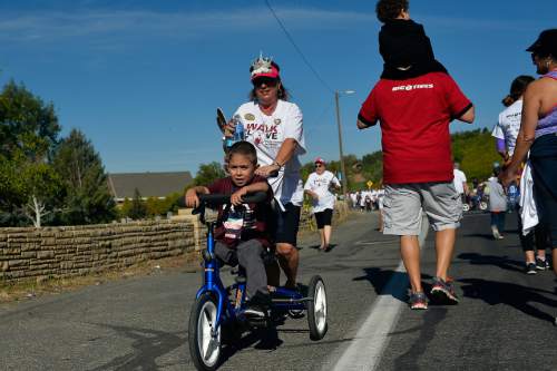 Chris Detrick  |  The Salt Lake Tribune
Adrian Paz, 7, and Patti Dawkins go along 11th Avenue during Shriners Hospitals for Children "Walk & Roll for Love" Saturday September 17, 2016.
