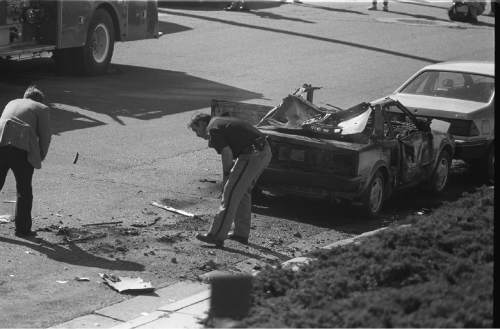 Tribune file photo
Investigators examine what is left of Mark Hofmann's car after one of his bombs blew up, injuring him, in 1985.