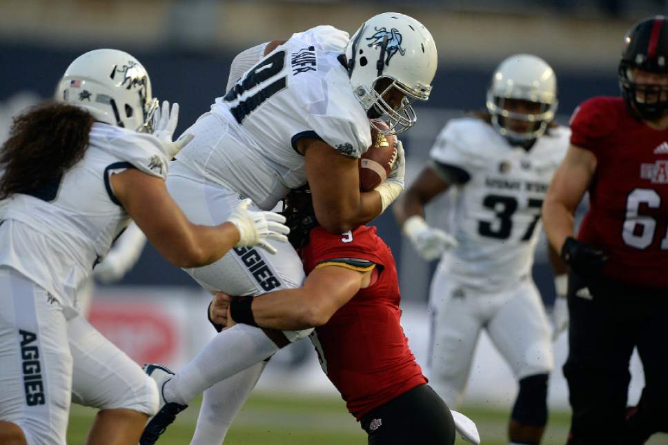 Chris Detrick  |  The Salt Lake Tribune
Utah State Aggies defensive end Siua Taufa (91) is tackled by Arkansas State Red Wolves quarterback Chad Voytik (9) after recovering a fumble during the game at Maverik Stadium Friday September 16, 2016.
