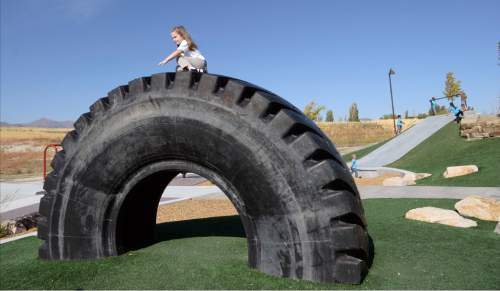 Al Hartmann  |  The Salt Lake Tribune
Child climbs huge tire donated from Kennicott on the amazing playground at the new Lodestone Park at 6200 S. 6200 W. Tuesday September 20.   Salt Lake County Mayor Ben McAdams and government officials from Kearns and West Valley City dedicated the new regional park built with funds from a 2012 parks bond on the Kearns/West Valley City border.  Larry H. Miller Charities donated several outdoor basketball courts to the park.