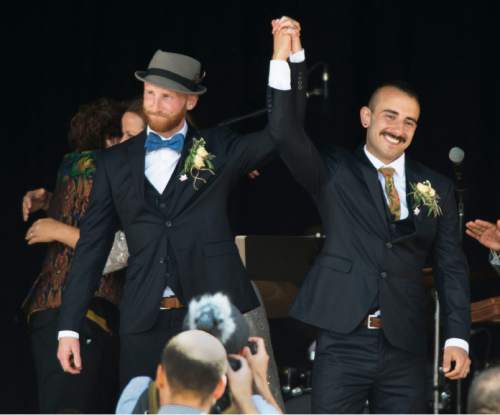 Steve Griffin  |  The Salt Lake Tribune
Derek Kitchen and Moudi Sbeity, the lead plaintiffs from the landmark Utah case that legalized same-sex marriage, hold their hands up after getting married in a large public ceremony at the Gallivan Center Plaza in Salt Lake City, Sunday, May 24, 2015.