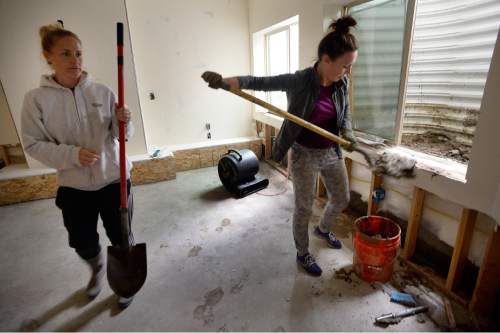 Scott Sommerdorf   |  The Salt Lake Tribune  
Tracy Brady, left, helps her neighbor Melissa Nelson, right, clean up her basement after a heavy overnight storm flooded their basement on Cedar Drive in Price, Friday, September 23, 2016. They were in the finishing stages of digging out about two feet of mud and water that poured into the basement from the windows at right.