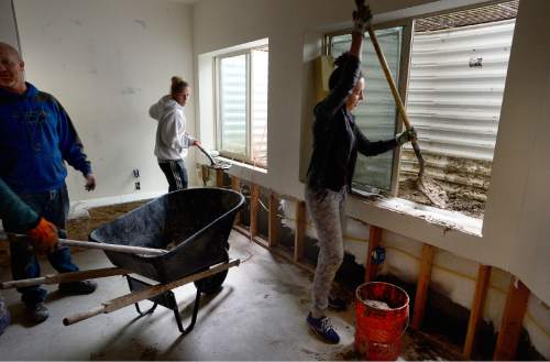 Scott Sommerdorf   |  The Salt Lake Tribune  
Tracy Brady, center, helps her neighbors Dave Nelson, left, and Melissa Nelson, right, clean up her basement after a heavy overnight storm flooded their basement on Cedar Drive in Price, Friday, September 23, 2016. They were in the finishing stages of digging out about two feet of mud and water that poured into the basement from the windows at right.