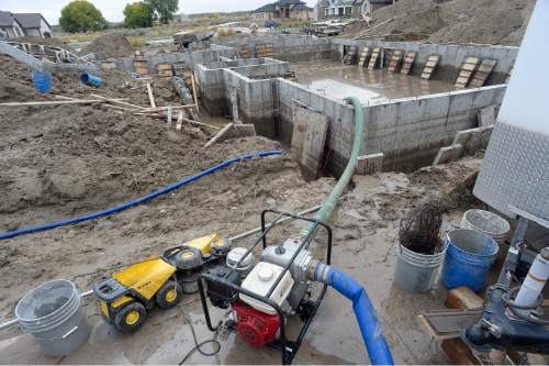 Scott Sommerdorf   |  The Salt Lake Tribune  
A pump empties out the last few feet of water from an unfinished foundation and basement of a home under construction on Balsam Way in Price, Friday, September 23, 2016. Earlier in the day residents say the water was up to the top of the cement walls.