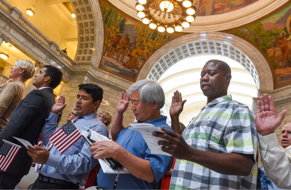 Francisco Kjolseth | The Salt Lake Tribune
Joining the 132 citizen applicants from 49 countries, Cristian Olivera from Peru, S.K. Han from South Korea and Jerry Flowers from Belize, from left, take the oath of allegiance during at the Utah Capitol on Friday, Sept. 30, 2016, during a special naturalization ceremony.