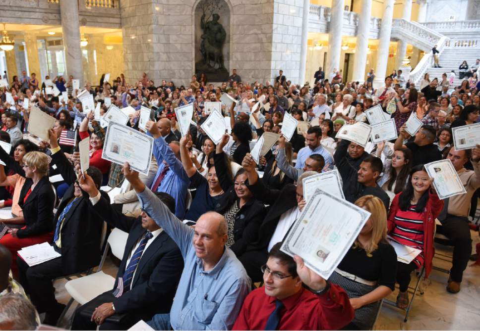 Francisco Kjolseth | The Salt Lake Tribune
Newly appointed U.S. citizens proudly hold up their new  certificates during a ceremony at the Utah state Capitol on Friday, Sept. 30, 2016. The U.S. Citizenship and Immigration Services hosted a naturalization ceremony for 132 citizenship applicants from 49 countries.