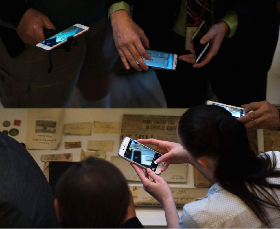 Steve Griffin  |  The Salt Lake Tribune
People use their cellphones to photograph historic items removed from a copper time capsule that was placed in the State Capitol in April 1914. Gov. Gary Herbert removed the items during a ceremony at the Capitol Rotunda in Salt Lake City Monday October 3, 2016.