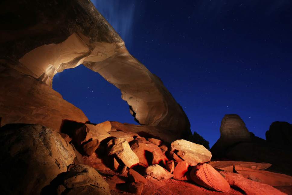 Francisco Kjolseth  |  The Salt Lake Tribune
Skyline Arch is lit up at night as the setting begins to reveal the sea of stars above during a camping trip to Arches National Park.