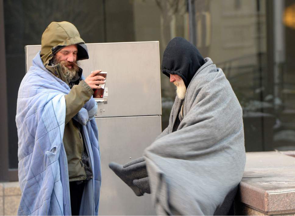 Al Hartmann  |  Tribune file photo
Homeless men in warm clothes and blankets share a hot coffee in the extreme cold temperatures on Main Street in Salt Lake City.
