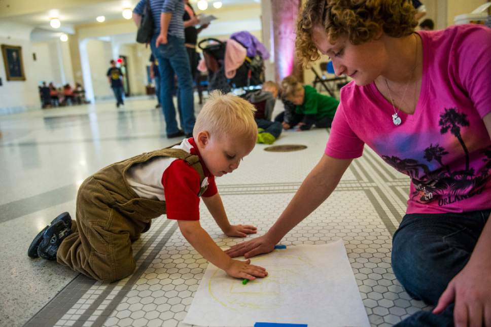 Chris Detrick  |  The Salt Lake Tribune
James Mark, 2, and Kathryn Dewees, 18, both of Kaysville, make a rubbing of the Davis County medallion during the Capitol Centennial Discovery Day at the Utah State Capitol Saturday October 8, 2016.