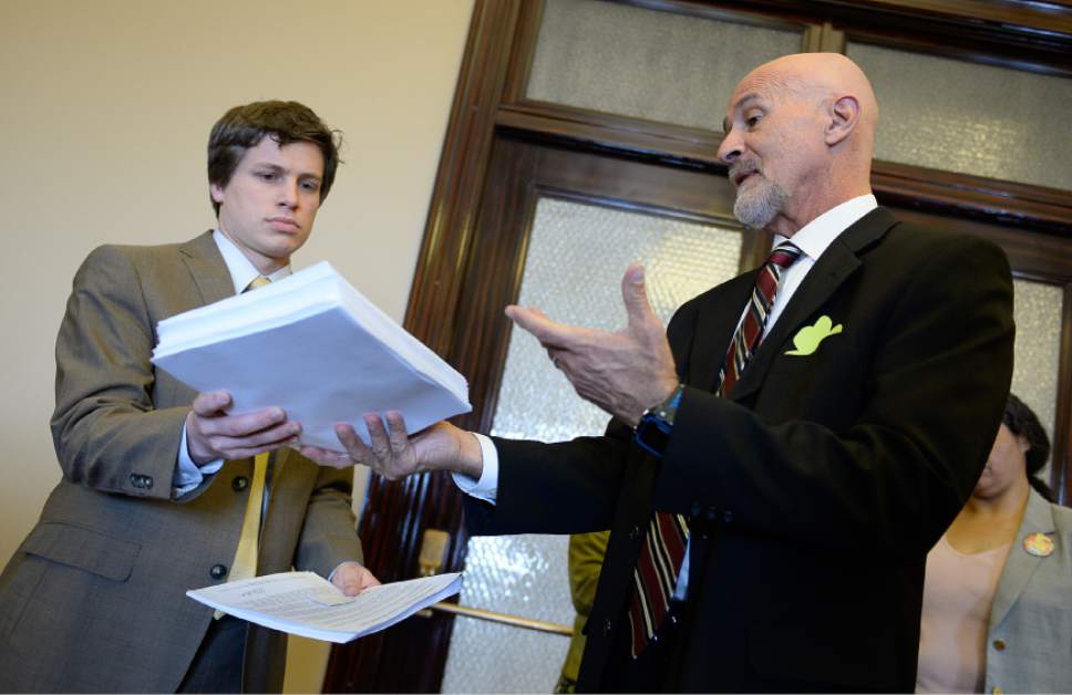 Francisco Kjolseth  |  The Salt Lake Tribune 
MoveOn member Ralph Dellapiana, right, who is also the director of Utahns for Alternatives to the Death Penalty, delivers 6,200 petitions to Constituent Services Director Austin Cox, who accepted them on behalf of Gov. Gary Herbert on Tuesday, March 17, 2015. Utah residents delivered the petitions, many from across the world and Utah, calling on the governor to veto execution by firing squad legislation.