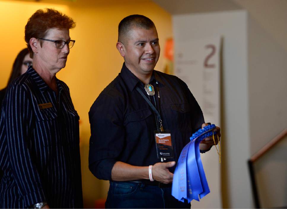 Scott Sommerdorf   |  The Salt Lake Tribune  
Artist Jesse Johnson of Petit Point Zuni Jewelry holds the blue ribbon for the Grand Prize he was awarded for his work at the Natural History Museum on Saturday, October 8, 2016.