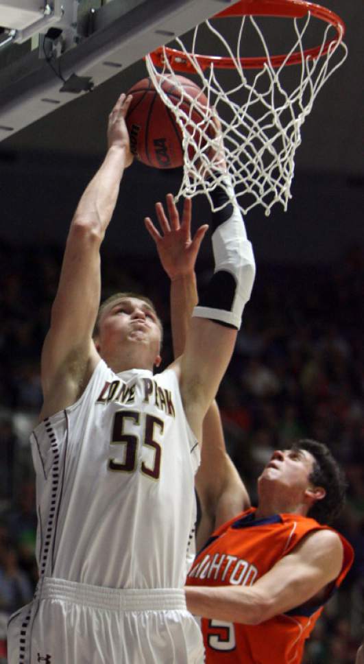 Kim Raff  |  The Salt Lake Tribune
(left) Lone Peak's Eric Mika dunks the ball over the head of (right) Brighton's Travis Devashrayee during the 5A state semifinal game at the Dee Event Center in Ogden on March 1, 2013. Lone Peak went on to win the game 53-27.
